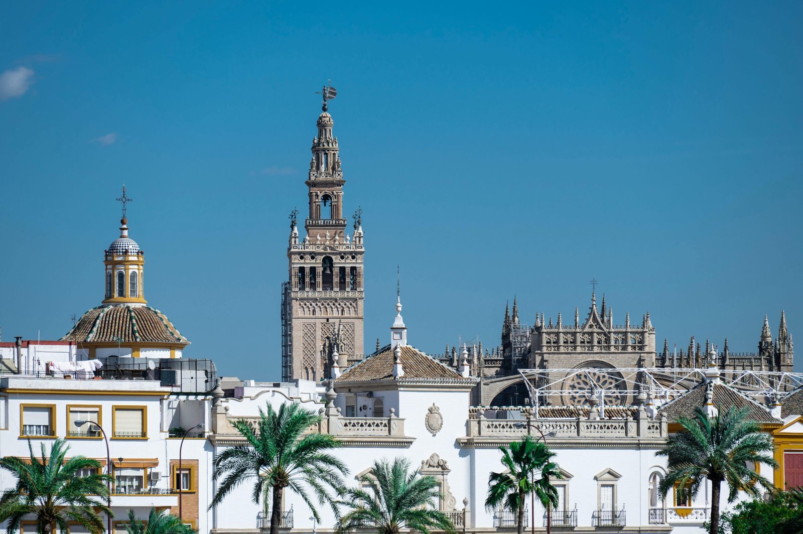Beautiful urban view of Sevilla with the iconic La Giralda under clear blue skies.
